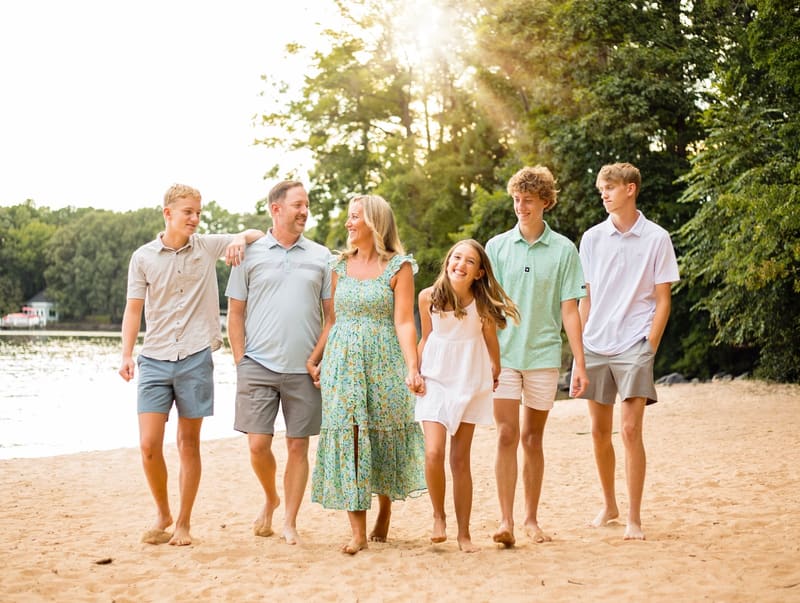 Family of four smiling together outdoors in golden light